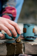Female hands pouring tea from teapot close-up