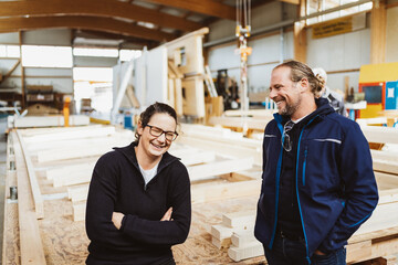 two carpenters standing in the workshop laughing and taking a break