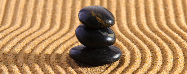Fototapeta na wymiar Stein liegt auf strukturiertem Sand im Japanischen ZEN Garten