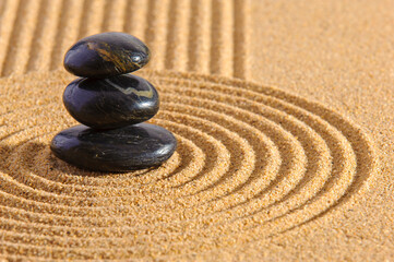 Fototapeta na wymiar Stein liegt auf strukturiertem Sand im Japanischen ZEN Garten