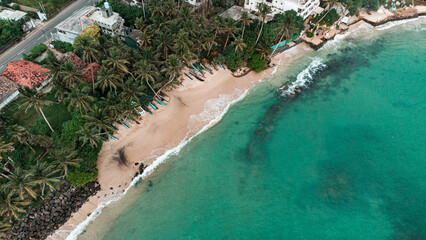 Tropical island with palms, ocean in the background, shot from a drone, top view.