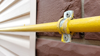 yellow gas pipe along the facade of a new building