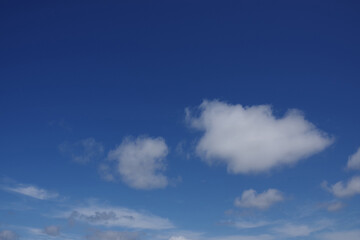 Some white clouds up in a deep blue sky