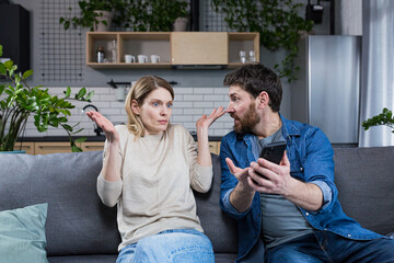 Family conflict at home. An angry man suspects a woman of treason, shouts at her, demands...