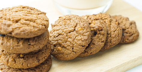 Chocolate chip cookies and glass of milk on white background