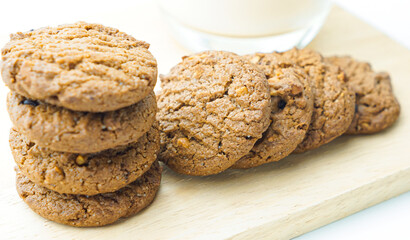 Chocolate chip cookies and glass of milk on white background