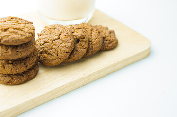 Chocolate chip cookies and glass of milk on white background