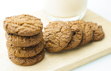 Chocolate chip cookies and glass of milk on white background