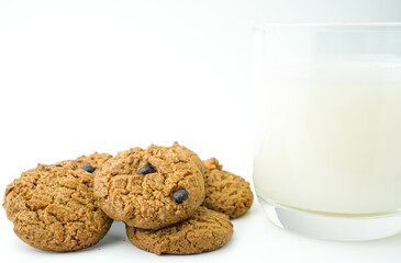 Chocolate chip cookies and glass of milk on white background