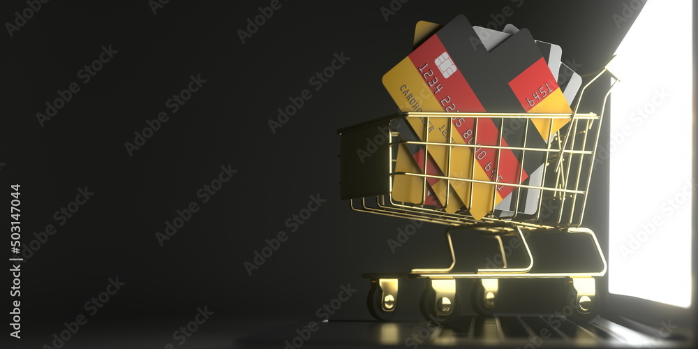 Poster bank card mockups with flags of germany in a small shopping cart on the laptop. 3d rendering