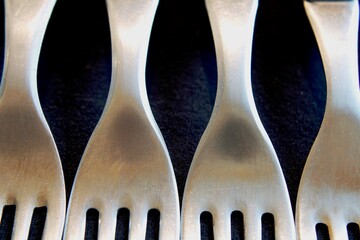Metal de acero inoxidable para tenedores de comida, con luz lateral con brillos del acero en bokeh,...