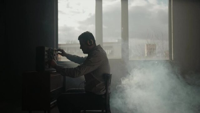 Secret agent listens on the reel tape recorder. Officer wiretapping in headphones. Spying of conversations. Intelligence gathering. Espionage concept. Report information to superiors.