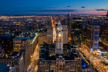 Aerial Drone View of Philadelphia Skyline at Sunset with Glowing City Lights with Town Hall in Foreground 