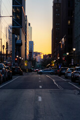 Cars Driving at Sunset by Buildings in Philadelphia