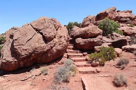 Pathway with steps between large red rocks in Canyonlands National Park, Utah, USA