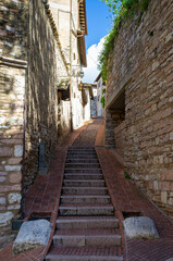Fototapeta na wymiar Old stairway street in the medieval village of Assisi, in springtime (Umbria, central Italy). It's world famous as the city of St. Francis.