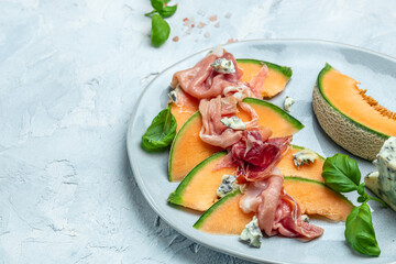 appetizer with sweet melon and ham, dorblu stilton dairy product, blue cheese roquefort gorgonzola,...