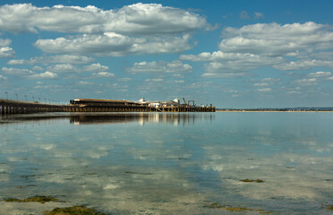 Fototapeta na wymiar Reflections: clouds and pier at low tide