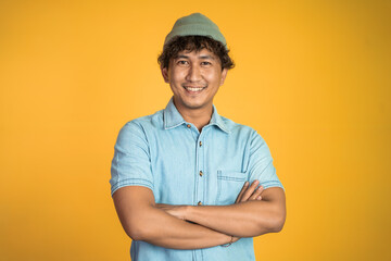 portrait of young asian man stand with crossed hands on isolated background