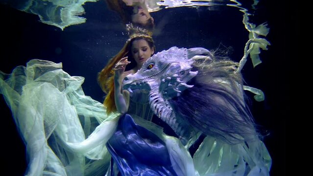 supernatural underwater shot, young princess and her tamed dragon, myth and fairytale