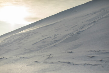 Snowy slope. Snowdrifts in winter. Slide of snow.