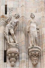 Obraz premium The Saint Erasmus of Formia statue on Milano Cathedral or Duomo, is the cathedral church of Milan, Lombardy, Italy. Dedicated to the Nativity of St Mary (Santa Maria Nascente)