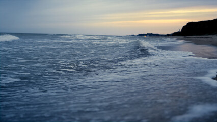 Sunset sea beach waves crashing romantic island coast. Ocean blue water splash.