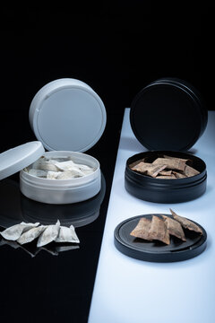 Closeup of two Swedish smokeless tobacco products. Snus cans with white and regular portion snuff