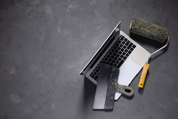 Computer laptop on cement floor. Laptop and construction tools