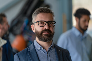 Portrait of male chief engineer in modern industrial factory looking at camera.