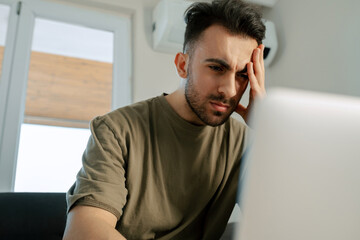 Thoughtful young man, adult male reading sexually transmitted diseases articles online, deep in...