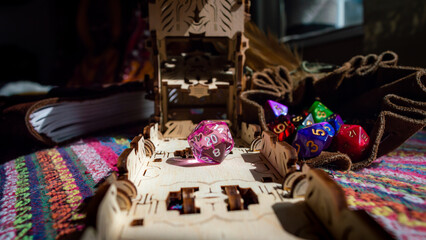 Pink d20 and wooden dice tower