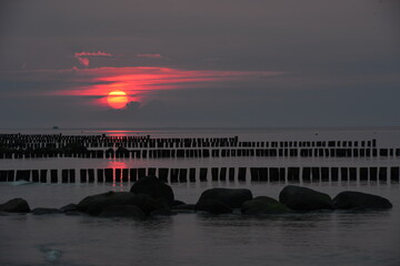 Fototapeta na wymiar Sonnenuntergang Sonnenaufgang Ostsee Buhnen Steine Menschen Touristen