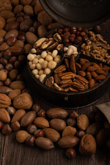 Festive mixed nuts grouped together on a dark wood background