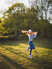 Young teenage girl dancing in park at sunset  her long hair flying © Lana