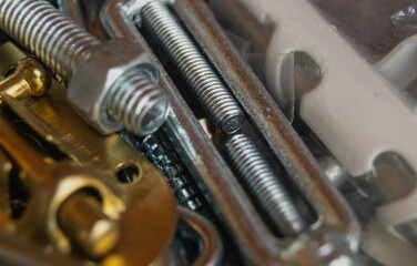 Close up of metal stuff. Bolts with disk in plastic box. Metal bolts close up. Long bolts. Long metal bolts. Shining bolts and nuts, blue toned photo. Metal bolts close up