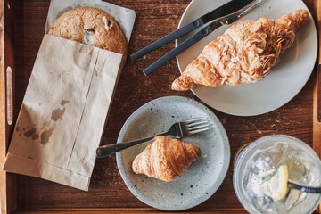 Woman is having croissant and iced lemon tea in the cafe. High quality photo