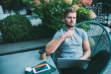 Pensive man working on project using laptop