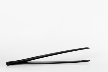 Black tweezer tongs for cooking and serving food