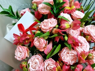 close-up photo of white envelope with red ribbon. It is invitation envelope, gift certificate, card, wedding invitation and a present. Concept of taking care and presents