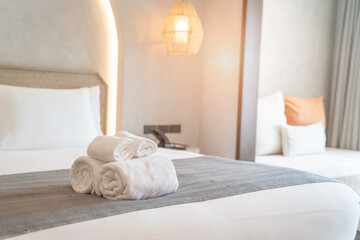 Fototapeta na wymiar White towels on bed decoration in stylish bedroom interior