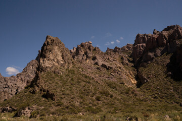 View of the arid desert and rocky mountains under a blue sky. 