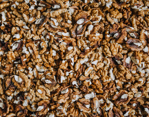 Background, texture of many brown walnuts, shelled nuts lying on the table. Food photography, top view, concept.