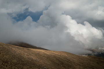 a beautiful cloud creeps along the mountain slope