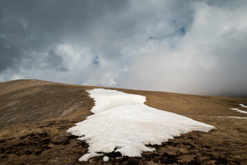 not melted glacier on a mountain slope and clouds