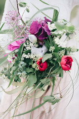 happy bride in wedding dress holds beautiful spring wedding bouquet in her hands