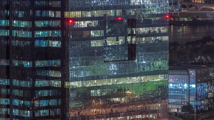 Windows in high-rise building exterior in the late evening with interior lights on timelapse