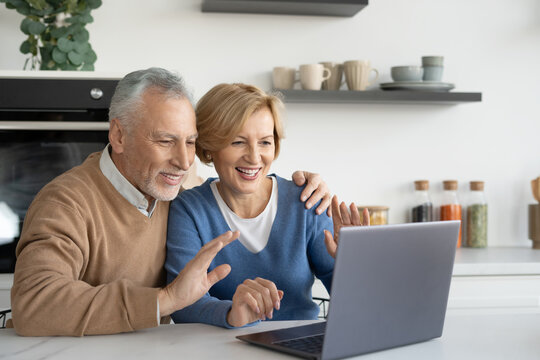 Mature married family couple making video call on laptop