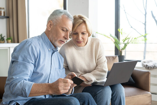 Mature Family Couple Use Bank Card For Online Shopping