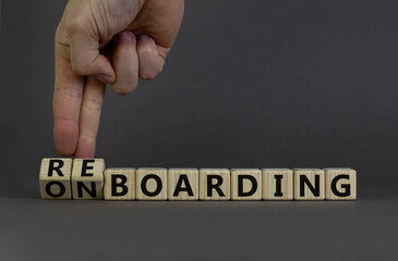Onboarding or reboarding symbol. Businessman turns wooden cubes and changes words Onboarding to Reboarding. Beautiful grey table grey background. Business onboarding or reboarding concept. Copy space.
